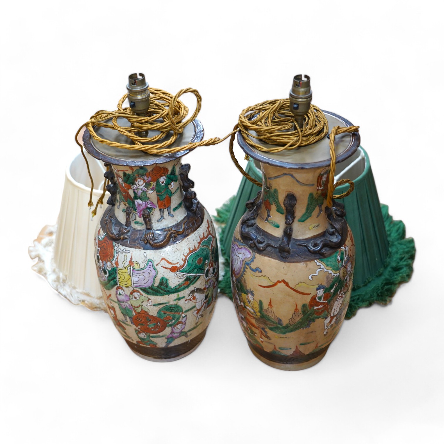 A pair of early 20th century Chinese famille verte crackle glaze ‘warrior’ vases converted to lamps with shades, height 44cm. Condition - fair to good